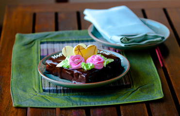 Delicious chocolate cake decorated with pink flower cream