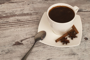 A cup of fragrant morning coffee and a beautiful cinnamon.