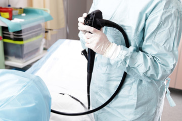 Lekarz trzyma głowicę operacyjną kolonoskopu.   - obrazy, fototapety, plakaty