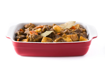 Beef meat stewed with potatoes, carrots and spices in ceramic pot isolated on white background

