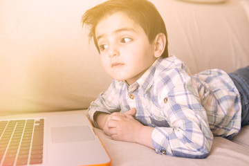Little boy surfing on his laptop