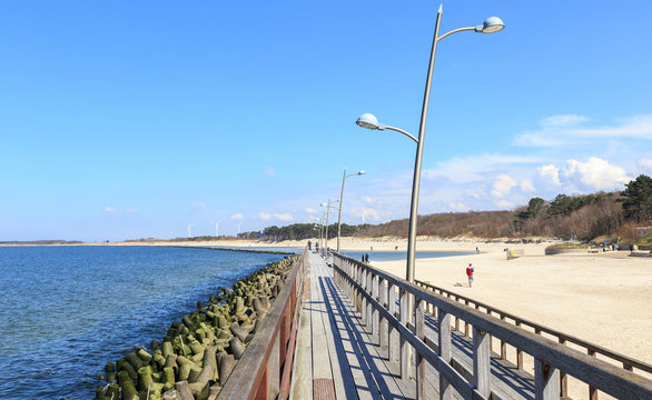 Darł&oacute;wek, plaża na wybrzeżu Bałtyku. Widok infrastruktury chroniącej przed falami i służącej wypoczywającym tu ludziom