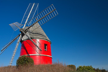 beautiful wind red mill rising up in blue sky, nailloux, france