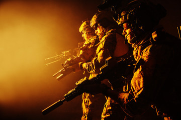 Group of security forces in Combat Uniforms with rifles, lined in the face of danger. Facing enemy,...