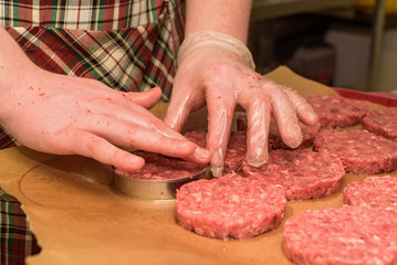 Hands kooking burger cutlets close up