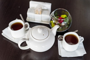 Teapot and cups of tea in cafe