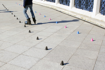 Roller skater practicing slalom along a line of cones
