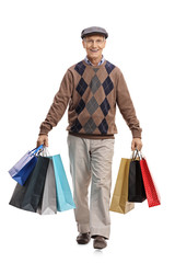 Elderly man carrying shopping bags and walking towards the camera