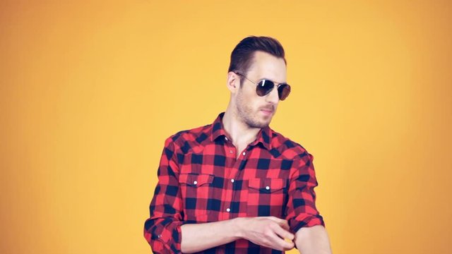 the guy rolls his sleeve plaid shirt