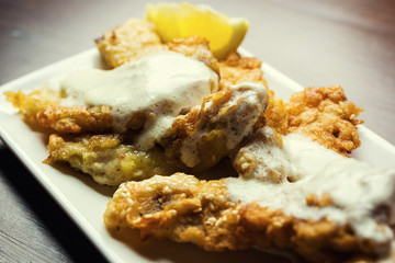 Fish fried in batter,Delicious battered fish on a plate with chips,Fish and chips meal.Battered cod with fries.