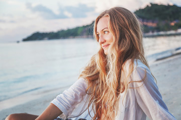 Portrait of an attractive young woman with long hair on the sea shore
