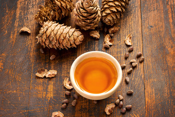 Cedar oil, nuts and cones On a wooden background. Top view
