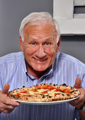 Abuelo feliz comiendo pizza. El anciano come pizza.