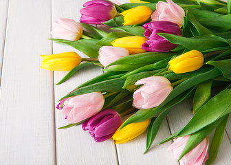 Bright tulips bouquet on white wood background, copy space