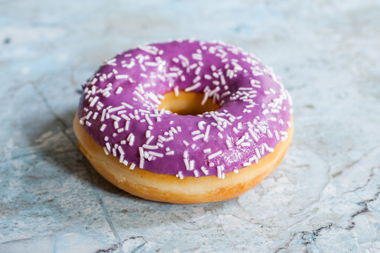 munk med lila galcyr och str&ouml;ssel p&aring; marmor bakgrund