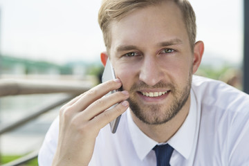 Portrait of blonde business man talking on the phone