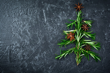 Christmas tree of rosemary and anise on a black plate background. Selective focus.Top view. Place for text. © kasia2003