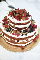 Vertical shot of a rustic style  wedding cake with fresh berries decoration