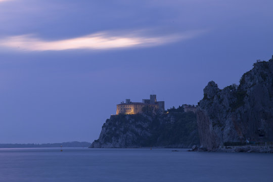 The Duino castle at blue hour from Porto Piccolo's beach in Sistiana, Trieste, Italy