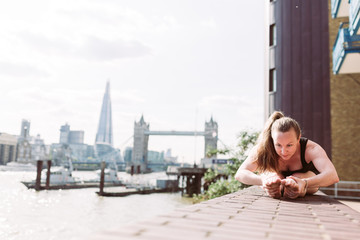 Woman in yoga position in fron of Tower Bridge, London