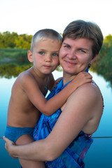 Fototapeta na wymiar Portrait of a mom, who hugs his young son
