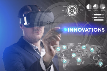 Business, Technology, Internet and network concept. Young businessman working in virtual reality glasses sees the inscription: Innovations