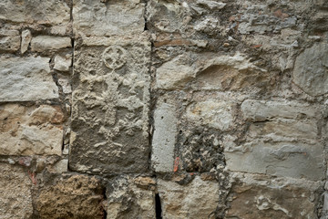 Wall with imprints of ancient frescoes. Khachkar.