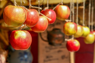 dojrzałe jabłka wiszące na sznurku na straganie jako ozdoba - obrazy, fototapety, plakaty