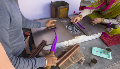 Indian Man Making cheap plastic bracelets near Samode Palace. Handmade traditional jewel Manufacturing Process in Rajasthan, India. Indian Samode village - Authentic tourist showplace