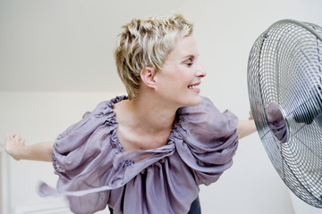 Woman leaning near fan