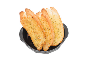Garlic bread in black bowl isolated on white background.