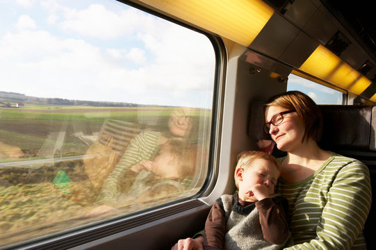 Mother and son asleep on train
