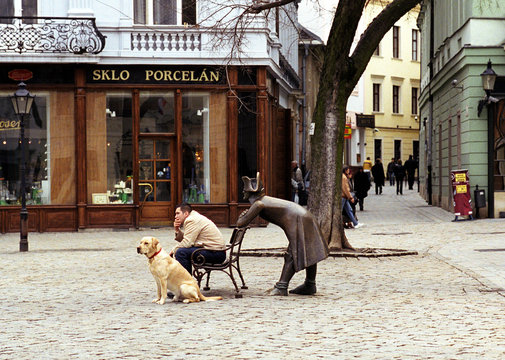 Men and dog sitting with statue