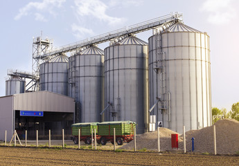 Agricultural silos for grain crops / grain silos (wheat, corn, soy, etc). Trailers park in front of...