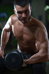 Fototapeta na wymiar Muscular bodybuilder working out in gym