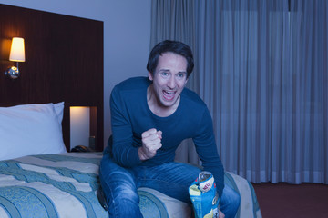 man watching TV, loaded with emotion