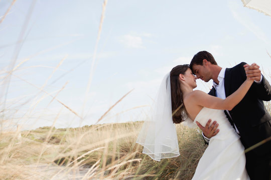 bride and groom dancing on beach