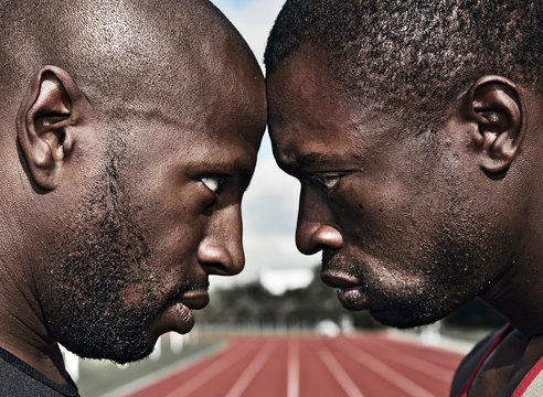 2 male athletes stare, head to head
