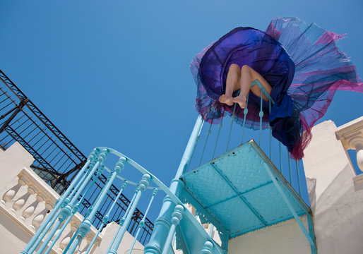 Woman sitting on staircase railing