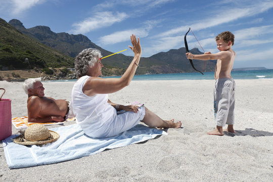 Boy shooting grandmother with toy arrow