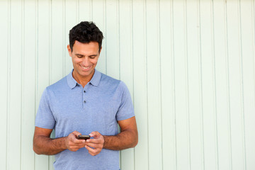 cool middle age man smiling and looking at cellphone