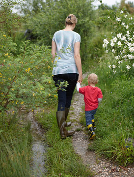 Mother and son walking on dirt path