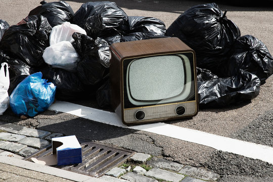 Retro television with pile of rubbish bags