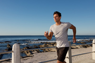 active middle age man jogging outside by sea