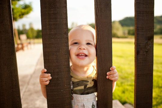 Toddler looking through wooden gate