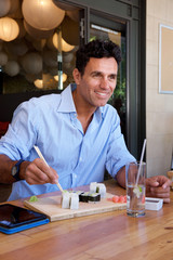 businessman sitting at restaurant eating sushi