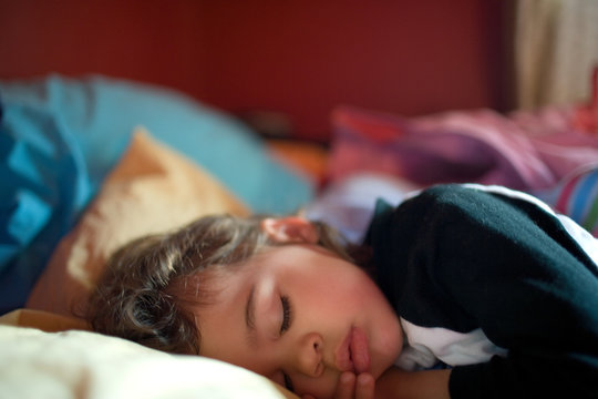 Young girl asleep on bed