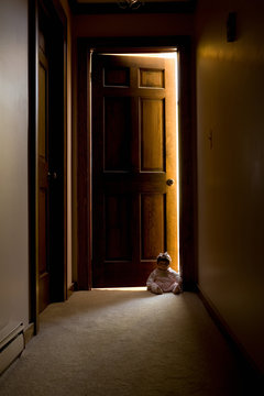 Doll sitting in doorway in hallway