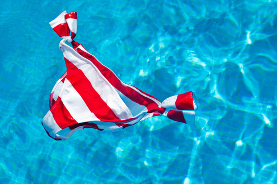 Red and white striped bikini bottoms floating on water surface