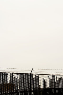 Barbed wire fence and skyline, New York City, New York, USA
